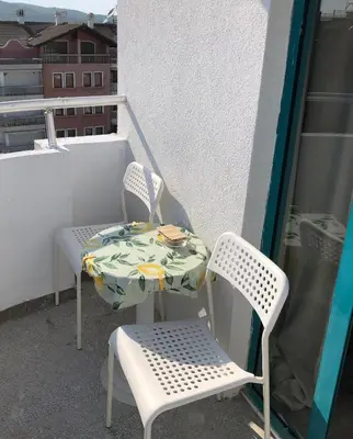 a table and two chairs on a balcony at Студио - Морско бягство in Primorsko