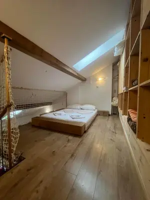 a bedroom with a large bed and a wooden floor at Blue Sea Side Studio in Varna City