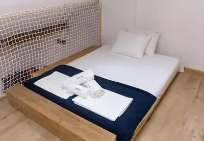 a small bed with white sheets and towels on it at Blue Sea Side Studio in Varna City