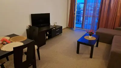 a living room with a couch and a tv at Holidays Apartment Atlantis Sarafovo in Burgas City