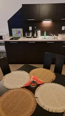 a kitchen with a table with mats on it at Holidays Apartment Atlantis Sarafovo in Burgas City