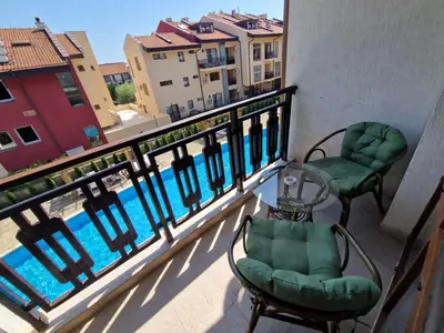 a balcony with two chairs and a view of a pool at MitProt Panorama Bay 2 Luks Apartment 110 in Sveti Vlas