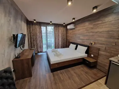 a bedroom with a white bed and a wooden wall at Mit Prot Panorama Bay 2 luks Studio 40 in Sveti Vlas