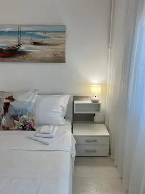 a bedroom with a bed with a painting on the wall at Tei-Zi apartments2 in Burgas City