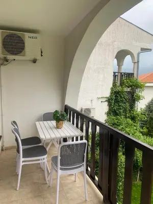 a balcony with a table and chairs and a heater at Cozy apartment in Kambani 1 in Sveti Vlas