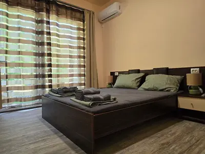 a large bed in a room with a large window at Ах, морето !!! in Tsarevo