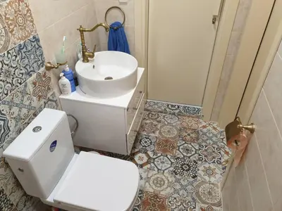 a bathroom with a white toilet and a sink at Solar Rise apartment in Pomorie