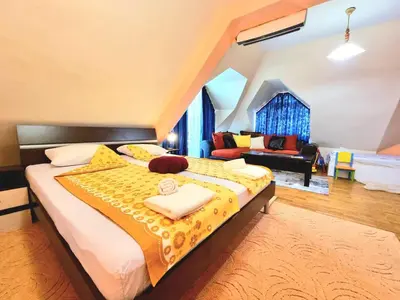 a bedroom with a large bed with a yellow blanket at Two-Floor Sunny Apartment in City Centre in Burgas City
