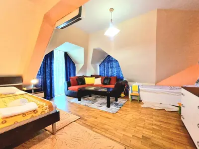 a living room with a couch and a bed at Two-Floor Sunny Apartment in City Centre in Burgas City
