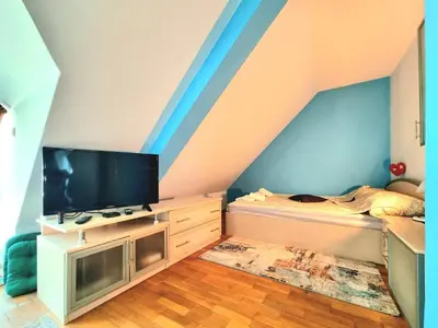 a room with a bed and a tv on a wall at Two-Floor Sunny Apartment in City Centre in Burgas City