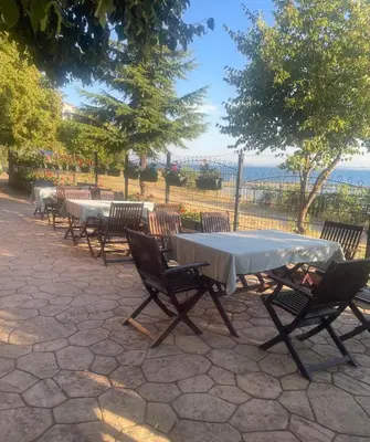 a group of tables and chairs with the ocean in the background at Marina Cape Sky View Lux Apartment in Aheloy in Aheloy