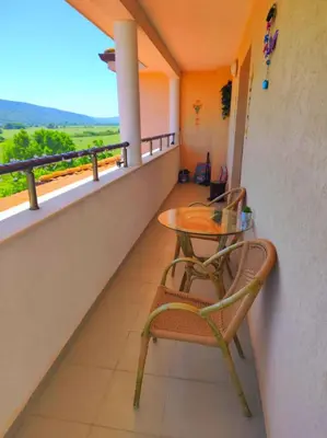 a balcony with two chairs and a table at Apartment Sunrise in Obzor
