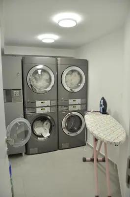a laundry room with three washing machines and a stool at Teracite in Varna City