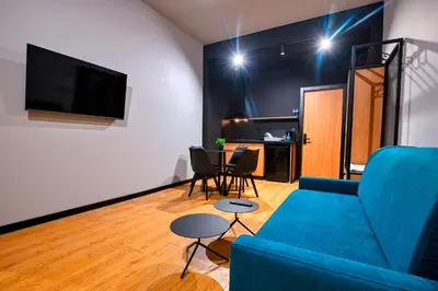 a living room with a blue couch and a table at Smart Rooms in Varna City