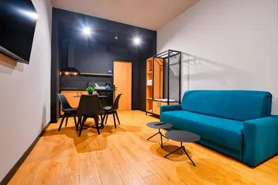 a living room with a blue couch and a table at Smart Rooms in Varna City