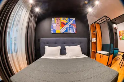 a bedroom with a bed and a painting on the wall at Smart Rooms in Varna City