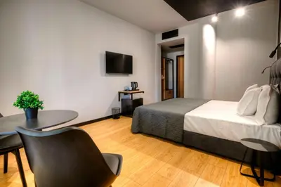 a bedroom with a bed and a desk and a table at Smart Rooms in Varna City