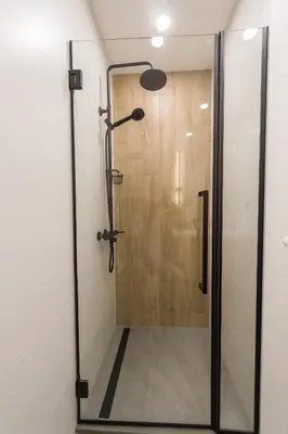 a shower with a glass door in a bathroom at KASHMIR Deluxe apartment with Parking in Burgas City