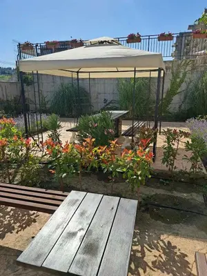 a picnic table and an umbrella in a garden at Sunny holidays in Byala