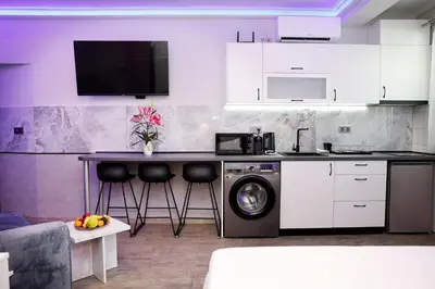 a kitchen with a washing machine and a table at Deluxe 3 Studio City Center in Burgas City