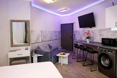 a living room with purple walls and a purple couch at Deluxe 3 Studio City Center in Burgas City