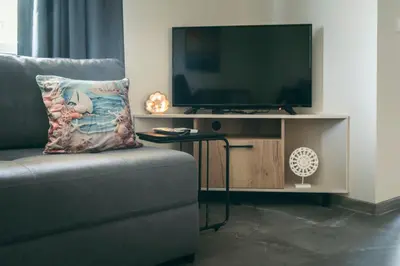 a living room with a couch and a flat screen tv at Paradise villas in Sozopol