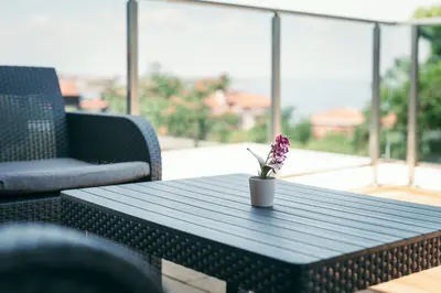a coffee table with a flower on a balcony at Paradise villas in Sozopol