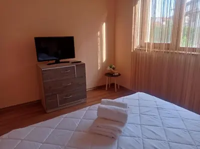 a bedroom with a bed and a television on a dresser at Апартамент РАЯ in Sozopol