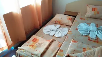 a bed with bows on it in a room at Guest House Malkata Stopanka in Primorsko