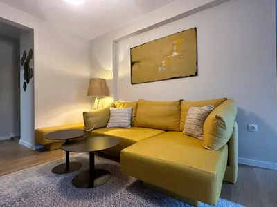 a living room with a yellow couch and a table at Cosy Apartment - Top Location in Burgas City