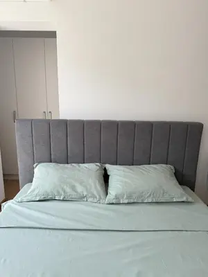 a bed with a gray headboard with two white pillows at VP Martini in Sunny Beach