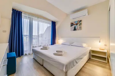 a bedroom with a large bed and a large window at AT apartment - Sea View in Varna City