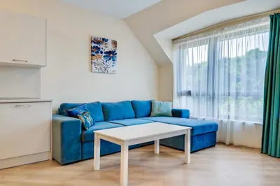 a living room with a blue couch and a table at AT apartment - Sea View in Varna City