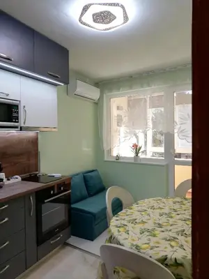 a kitchen with a bed and a table in a room at SPS Apartment in Varna City