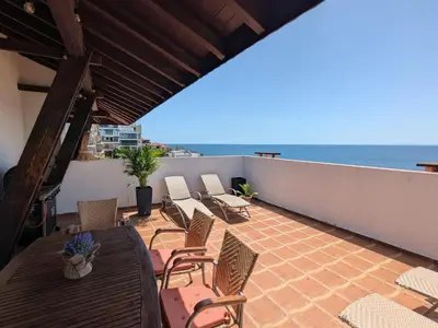 a balcony with chairs and tables and the ocean at Beachfront Apartment Sveti Vlas in Sveti Vlas