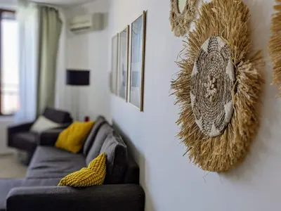 a living room with a couch and a wall with a head on it at Beachfront Apartment Sveti Vlas in Sveti Vlas