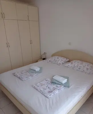 a white bed with two towels and two cabinets at Апартамент Плаж Червенка in Chernomorets