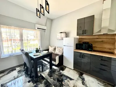 a kitchen with a dining table and a refrigerator at Апартамент СВЕТИ ВЛАС 1 in Sveti Vlas
