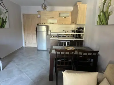 a kitchen with a table and a refrigerator at Kalia A5 Sunny Beach in Sunny Beach