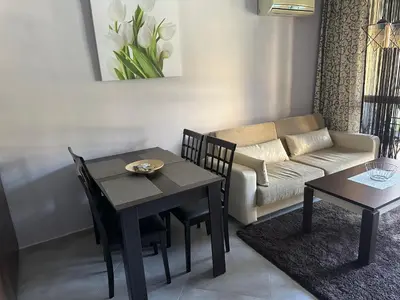 a living room with a table and a couch at Kalia A5 Sunny Beach in Sunny Beach
