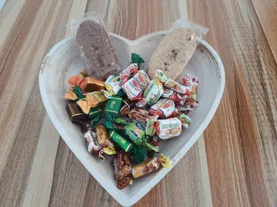 a white heart shaped bowl filled with candy and crackers at Apartments Lozenets in Lozenets