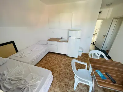 a small kitchen with two beds and a table and chairs at Apartments Lozenets in Lozenets
