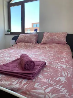 a bed with a purple blanket and pillows on it at 2 Bedroom Apartment at Kasandra in Sunny Beach