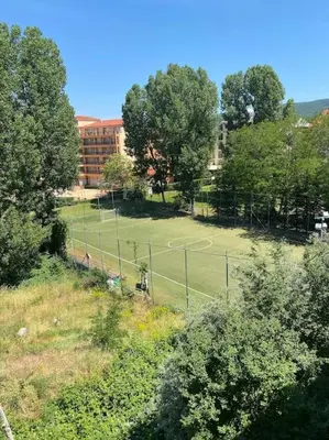 a tennis court in a field next to a building at 2 Bedroom Apartment at Kasandra in Sunny Beach