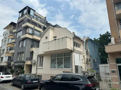 a large building with cars parked in front of it at Студио за гости При Нана in Burgas City