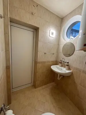 a bathroom with a sink and a toilet and a mirror at Студио за гости При Нана in Burgas City