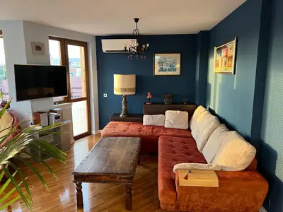 a living room with a couch and a tv at Roman Thermae Heritage Penthouse with Garage in Varna City
