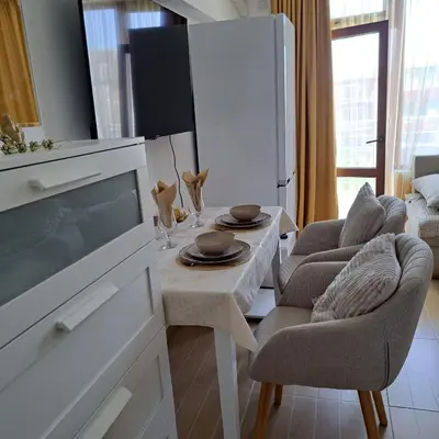 a living room with a table and two chairs at Студио Дарис in Nesebar