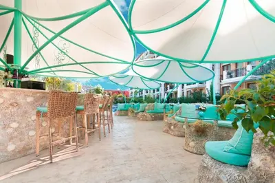 a patio with tables and chairs and umbrellas at HARMONY SUITES Grand Resort PREMIUM Ferienwohnung in Sunny Beach