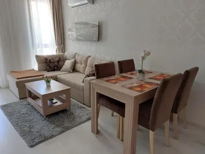 a living room with a table and a couch at HARMONY SUITES Grand Resort PREMIUM Ferienwohnung in Sunny Beach